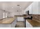 Open concept kitchen with stainless appliances, granite counters and white cabinets at 42311 W Bunker Dr, Maricopa, AZ 85138