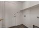 This laundry room features a door and a shelf for extra storage at 42311 W Bunker Dr, Maricopa, AZ 85138