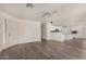 Open-concept living room with laminate floors and freshly painted white walls at 42311 W Bunker Dr, Maricopa, AZ 85138