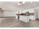 Spacious living room featuring laminate floors and open access to a kitchen at 42311 W Bunker Dr, Maricopa, AZ 85138