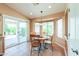 A bright dining area with a bay window, sliding glass door, and terra cotta tile flooring at 426 N Santiago Trl, Casa Grande, AZ 85194