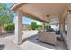 Covered patio with cushioned chairs, decorative rock, a fountain, and lush landscaping at 426 N Santiago Trl, Casa Grande, AZ 85194