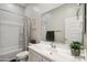 Bright bathroom featuring a vanity, toilet, shower-tub combo with striped curtain, and fresh green plants at 460 W Glacier Bay Dr, San Tan Valley, AZ 85140