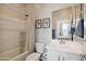 Clean bathroom with a tub-shower, white vanity, framed art, and sleek fixtures at 460 W Glacier Bay Dr, San Tan Valley, AZ 85140