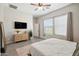 Comfortable bedroom with a dresser, TV, large window, and neutral tones for a relaxing atmosphere at 460 W Glacier Bay Dr, San Tan Valley, AZ 85140