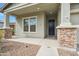 Charming front porch features stone pillars and a modern black door, enhancing curb appeal at 460 W Glacier Bay Dr, San Tan Valley, AZ 85140