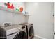 Bright laundry room featuring modern, front loading washer and dryer, with built-in shelving for storage at 460 W Glacier Bay Dr, San Tan Valley, AZ 85140