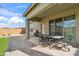 Covered patio with an outdoor dining table, brick pavers, synthetic grass, and barbecue grill at 460 W Glacier Bay Dr, San Tan Valley, AZ 85140