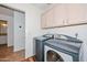 Laundry room features modern washer and dryer with plenty of cabinet space at 5226 W Pontiac Dr, Glendale, AZ 85308
