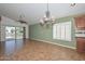 Bright living room featuring tile floors, high ceilings, a chandelier, and sliding doors to the backyard at 5226 W Pontiac Dr, Glendale, AZ 85308