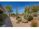 Backyard with a landscaped desert garden, showcasing native plants, cacti, and a charming stone water feature at 6094 E Evening Glow Dr, Scottsdale, AZ 85266