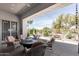 Inviting covered patio featuring cozy wicker chairs, a fire pit, and views of the landscaped backyard at 6094 E Evening Glow Dr, Scottsdale, AZ 85266
