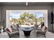 Relaxing covered patio area with comfortable wicker seating and a fire pit table overlooking a serene water feature at 6094 E Evening Glow Dr, Scottsdale, AZ 85266