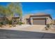 Attractive home exterior with a well-manicured front yard, desert landscaping, and a three-car garage at 6094 E Evening Glow Dr, Scottsdale, AZ 85266