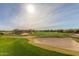 Scenic golf course view with sand traps, lush green grass, and desert landscaping under a blue sky at 6094 E Evening Glow Dr, Scottsdale, AZ 85266