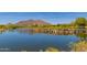Picturesque view of a lush golf course with a serene lake and desert mountain backdrop on a clear day at 6094 E Evening Glow Dr, Scottsdale, AZ 85266