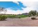 Scenic golf course view with sand traps, lush green grass, and mature trees under a blue sky at 6094 E Evening Glow Dr, Scottsdale, AZ 85266