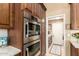 Bosch stainless steel double oven built into rich, dark wood cabinetry, showcasing modern kitchen design at 6094 E Evening Glow Dr, Scottsdale, AZ 85266
