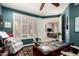 Stylish office featuring a dark teal accent wall, shuttered windows, and a view into the adjacent living room at 6094 E Evening Glow Dr, Scottsdale, AZ 85266