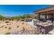 Inviting outdoor seating area with a cozy fireplace, offering views of the golf course and mountains at 6094 E Evening Glow Dr, Scottsdale, AZ 85266