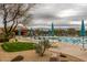 Resort-style pool showcasing lounge seating, umbrellas, well-manicured lawn, and natural desert landscape at 6094 E Evening Glow Dr, Scottsdale, AZ 85266