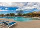 Beautiful community pool with lounge chairs, umbrellas, and desert landscaping set against a blue sky at 6094 E Evening Glow Dr, Scottsdale, AZ 85266