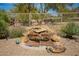 Charming rock water feature amidst desert landscaping, adding a tranquil ambiance to the outdoor space at 6094 E Evening Glow Dr, Scottsdale, AZ 85266