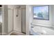 Bright bathroom featuring a walk-in shower, separate bathtub, and a scenic view at 6602 S 23Rd Ave, Phoenix, AZ 85041