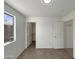 Cozy bedroom with neutral tile flooring, closet, window, and white walls, offering a serene retreat at 6602 S 23Rd Ave, Phoenix, AZ 85041