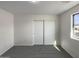Well-lit bedroom with closet, plush carpeting, and a view of the outside through a bright window at 6602 S 23Rd Ave, Phoenix, AZ 85041