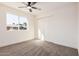 Carpeted bedroom with closet space, ceiling fan, and a large window at 6823 W Coolidge St, Phoenix, AZ 85033