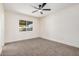 Carpeted bedroom with ceiling fan, white walls, and plenty of natural light at 6823 W Coolidge St, Phoenix, AZ 85033