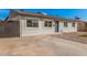Charming single-story home with gray brick, concrete driveway, and xeriscaped front yard at 6823 W Coolidge St, Phoenix, AZ 85033