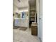 Bright bathroom featuring double sinks, modern lighting, linen closet and tile floors at 905 S 108Th Ave, Avondale, AZ 85323
