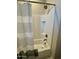 Modern shower-tub combo featuring white tiled walls, a built-in shelf, and bronze fixtures at 905 S 108Th Ave, Avondale, AZ 85323
