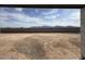 A view of the fenced-in backyard with gravel landscaping and mountain views at 9543 W Parkway Dr, Tolleson, AZ 85353