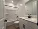 Full bathroom showcasing white cabinets, a bright white shower-tub combo and wood-style tile flooring at 9543 W Parkway Dr, Tolleson, AZ 85353