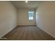 An empty, neutral carpeted bedroom illuminated by a window and a ceiling light at 9543 W Parkway Dr, Tolleson, AZ 85353