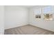 Bright bedroom features neutral carpet and two windows for natural light at 9543 W Parkway Dr, Tolleson, AZ 85353