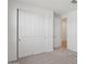 Bedroom with neutral carpet, sliding door closet and a door leading to hallway at 9543 W Parkway Dr, Tolleson, AZ 85353
