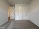 Neutral-carpeted bedroom showcasing a bright window, closet and an open doorway at 9543 W Parkway Dr, Tolleson, AZ 85353