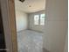 A bright bedroom features unfinished walls and flooring, complemented by two sunlit windows at 9543 W Parkway Dr, Tolleson, AZ 85353