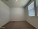 Bright bedroom featuring neutral carpet, a window and fresh white paint at 9543 W Parkway Dr, Tolleson, AZ 85353