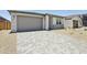 Inviting single-story home showcasing a spacious driveway, two-car garage and desert-style landscaping at 9543 W Parkway Dr, Tolleson, AZ 85353