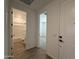 Bright hallway with views into the bathroom and bedroom, featuring wood-style tile flooring at 9543 W Parkway Dr, Tolleson, AZ 85353