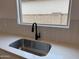 Close-up of a modern kitchen with stainless steel sink, quartz countertop and white cabinets at 9543 W Parkway Dr, Tolleson, AZ 85353