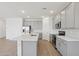 Bright kitchen with gray cabinets, stainless steel appliances, a subway tile backsplash, and a large white island at 9543 W Parkway Dr, Tolleson, AZ 85353