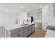Bright kitchen with gray cabinets, stainless steel appliances, a subway tile backsplash, and a large white island at 9543 W Parkway Dr, Tolleson, AZ 85353