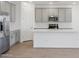 Bright kitchen with gray cabinets, stainless steel appliances, a subway tile backsplash, and a large white island at 9543 W Parkway Dr, Tolleson, AZ 85353