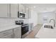 Bright kitchen with gray cabinets, stainless steel appliances, a subway tile backsplash, and a large white island at 9543 W Parkway Dr, Tolleson, AZ 85353